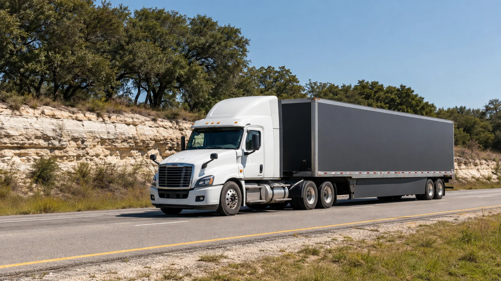 Illustrative unbranded cargo truck on a Central Texas road near limestone and live oaks